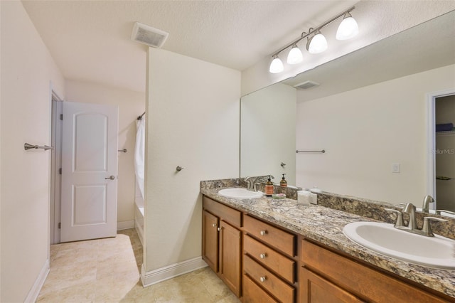 12218 Avondale Oak Pl, Riverview, FL 33578 - bathroom featuring double vanity, shower / bathtub combination with curtain, a textured ceiling, and tile patterned floors