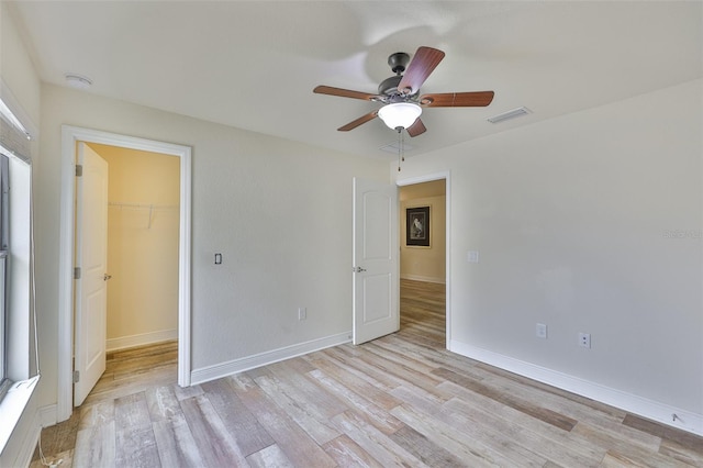 12218 Avondale Oak Pl, Riverview, FL 33578 - unfurnished bedroom with light wood-type flooring, a spacious closet, a closet, and a ceiling fan