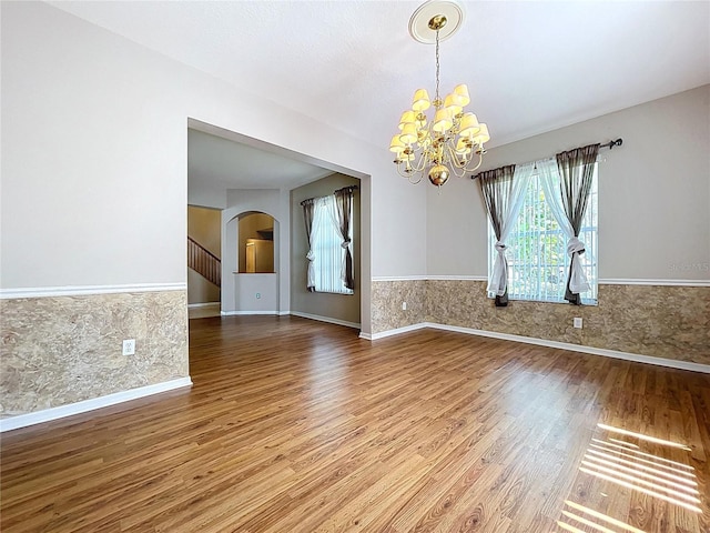 4222 Trumpworth Ct, Valrico, FL 33596 - spare room with wood finished floors, a chandelier, arched walkways, and wainscoting