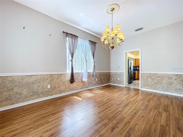 4222 Trumpworth Ct, Valrico, FL 33596 - empty room featuring a chandelier, wood finished floors, and a wainscoted wall