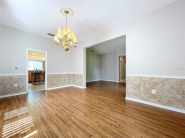 4222 Trumpworth Ct, Valrico, FL 33596 - unfurnished room with a chandelier, wood finished floors, and a wainscoted wall
