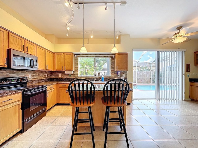 4222 Trumpworth Ct, Valrico, FL 33596 - kitchen with black range with electric stovetop, stainless steel microwave, a kitchen bar, decorative backsplash, and light tile patterned floors