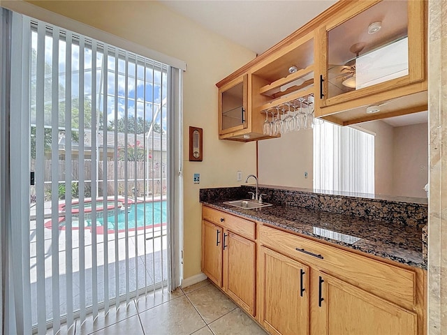 4222 Trumpworth Ct, Valrico, FL 33596 - kitchen with open shelves, light tile patterned flooring, dark stone counters, and glass insert cabinets