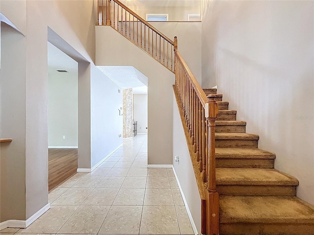 4222 Trumpworth Ct, Valrico, FL 33596 - staircase featuring tile patterned flooring, a towering ceiling, and arched walkways
