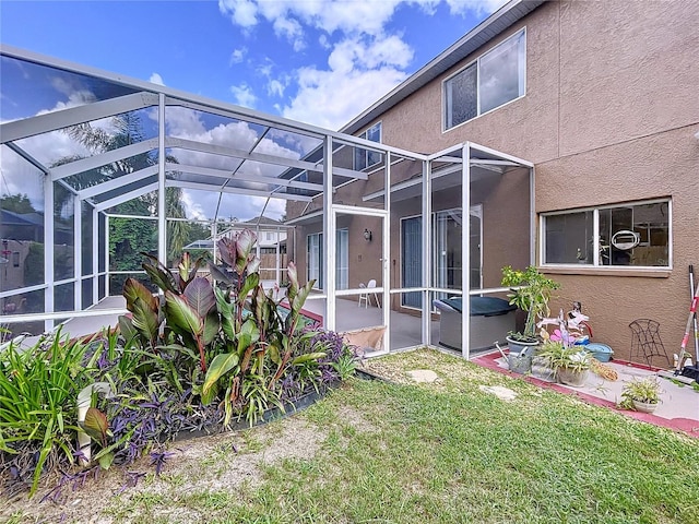 4222 Trumpworth Ct, Valrico, FL 33596 - rear view of property featuring a patio area, stucco siding, glass enclosure, and a lawn