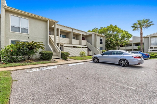 630 Windrush Bay Dr Unit 630, Tarpon Springs, FL 34689 - view of property featuring uncovered parking and stairway