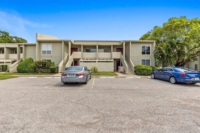 630 Windrush Bay Dr Unit 630, Tarpon Springs, FL 34689 - view of front of home featuring stairs, uncovered parking, and stucco siding