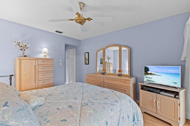 630 Windrush Bay Dr Unit 630, Tarpon Springs, FL 34689 - bedroom featuring light wood-style flooring, a textured ceiling, and ceiling fan