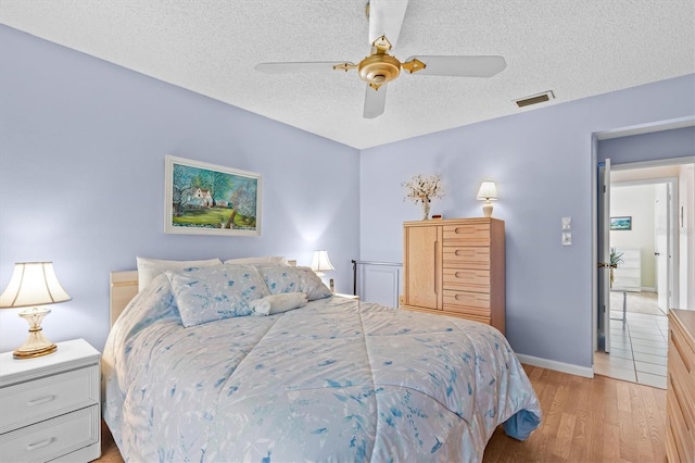 630 Windrush Bay Dr Unit 630, Tarpon Springs, FL 34689 - bedroom featuring a textured ceiling, light wood-style flooring, and ceiling fan