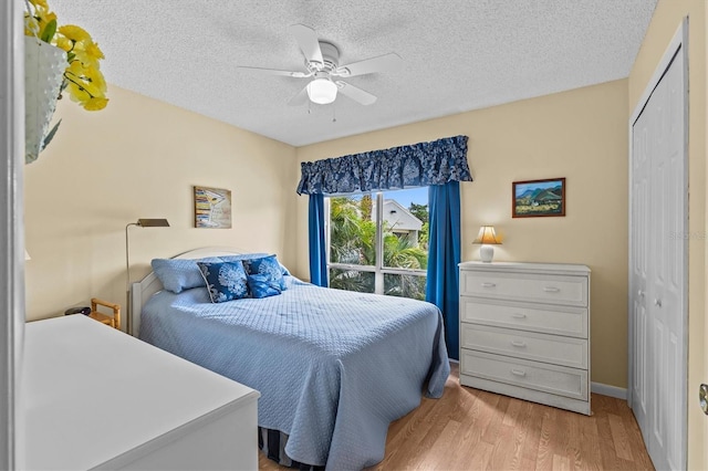 630 Windrush Bay Dr Unit 630, Tarpon Springs, FL 34689 - bedroom featuring a closet, light wood finished floors, a textured ceiling, and ceiling fan