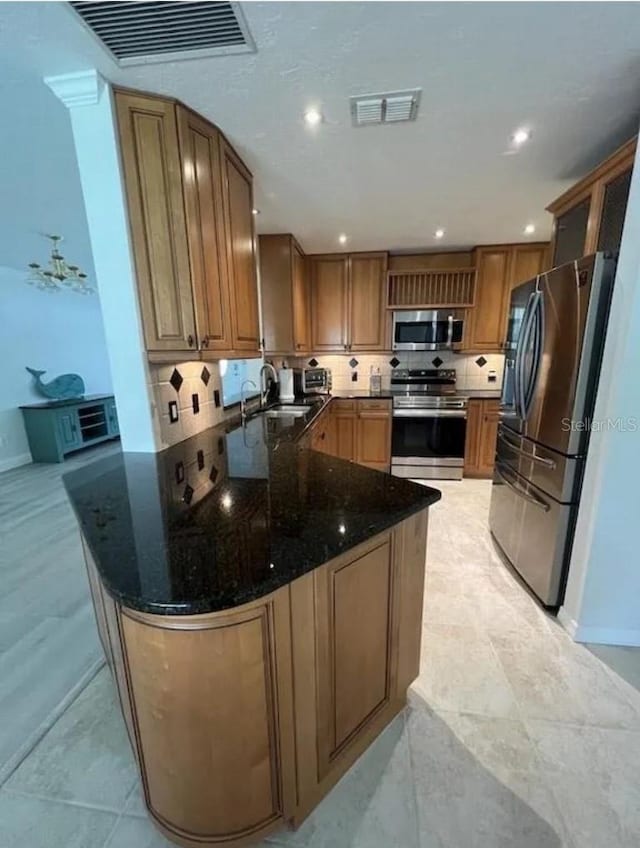 3856 Tarpon Rd, Venice, FL 34293 - kitchen featuring stainless steel appliances, a peninsula, dark stone counters, tasteful backsplash, and recessed lighting