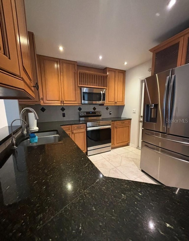 3856 Tarpon Rd, Venice, FL 34293 - kitchen featuring stainless steel appliances, recessed lighting, brown cabinetry, dark countertops, and tasteful backsplash