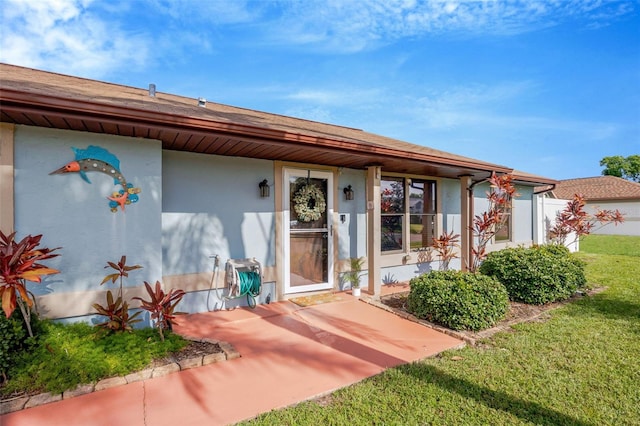 3302 69th St W, Bradenton, FL 34209 - view of exterior entry with stucco siding and a lawn