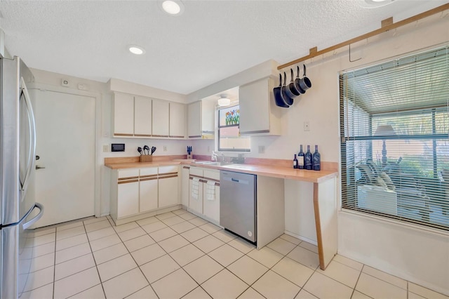 3302 69th St W, Bradenton, FL 34209 - kitchen featuring appliances with stainless steel finishes, a textured ceiling, white cabinetry, light tile patterned flooring, and recessed lighting