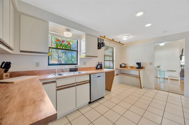 3302 69th St W, Bradenton, FL 34209 - kitchen with stainless steel dishwasher, white cabinetry, light tile patterned flooring, and recessed lighting