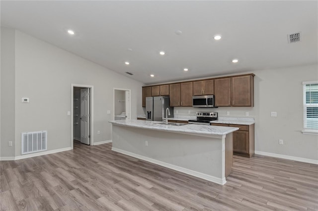 11958 Stone Pine St, Riverview, FL 33569 - kitchen with appliances with stainless steel finishes, vaulted ceiling, light wood finished floors, a center island with sink, and recessed lighting
