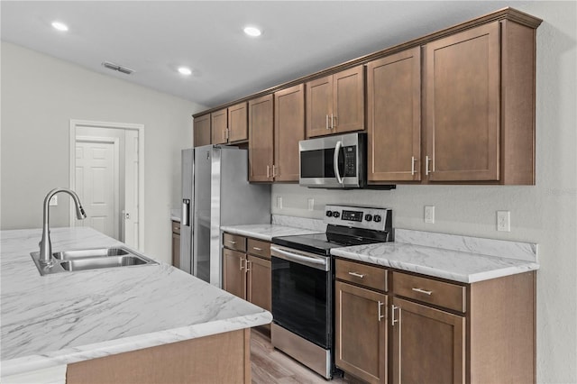 11958 Stone Pine St, Riverview, FL 33569 - kitchen with appliances with stainless steel finishes, light wood finished floors, recessed lighting, vaulted ceiling, and light stone countertops