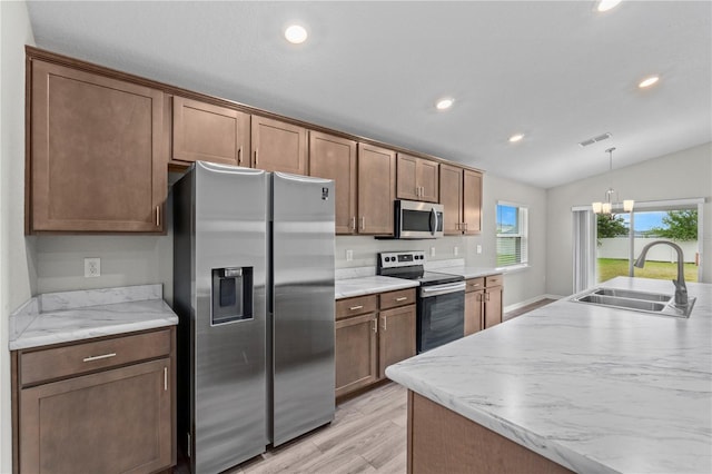 11958 Stone Pine St, Riverview, FL 33569 - kitchen with stainless steel appliances, recessed lighting, lofted ceiling, light wood finished floors, and hanging light fixtures