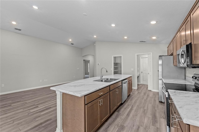 11958 Stone Pine St, Riverview, FL 33569 - kitchen with appliances with stainless steel finishes, a kitchen island with sink, light wood finished floors, arched walkways, and recessed lighting