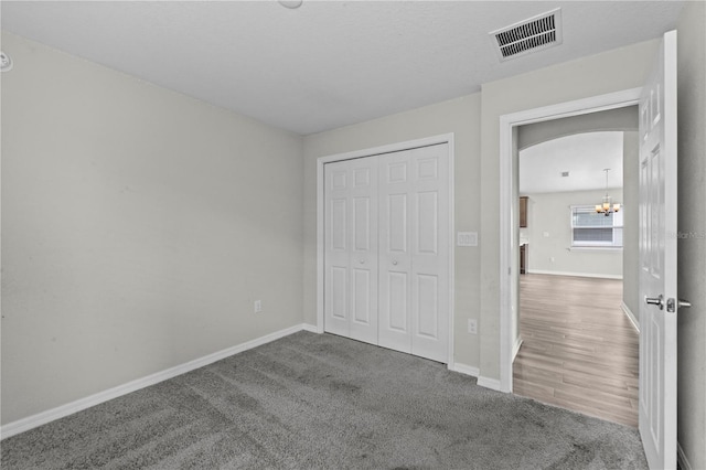 11958 Stone Pine St, Riverview, FL 33569 - unfurnished bedroom featuring a chandelier, a closet, carpet flooring, and arched walkways