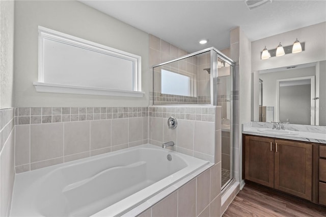 11958 Stone Pine St, Riverview, FL 33569 - full bath featuring a garden tub, a stall shower, vanity, and wood finished floors