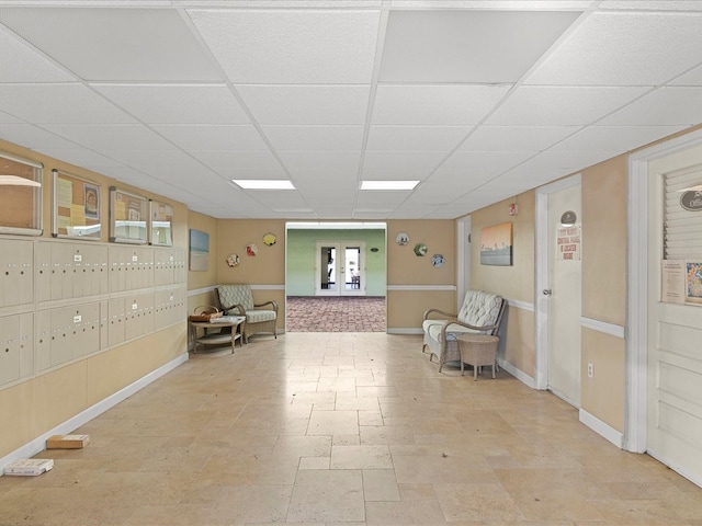 464 N Paula Dr Unit 106, Dunedin, FL 34698 - living area with a drop ceiling, french doors, light stone finish floors, and mail area