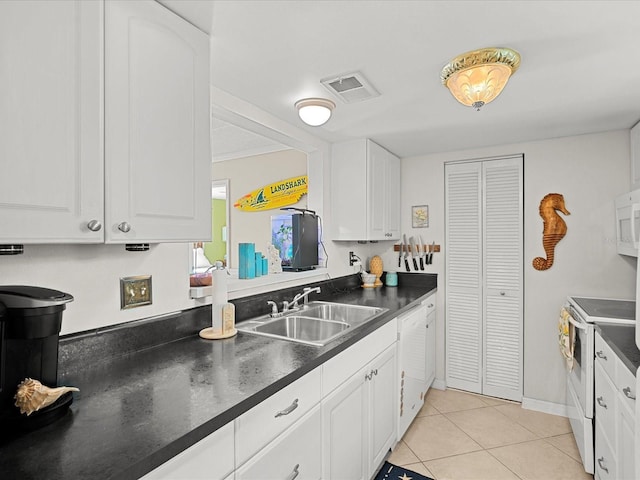 464 N Paula Dr Unit 106, Dunedin, FL 34698 - kitchen featuring white appliances, dark countertops, white cabinets, and light tile patterned floors