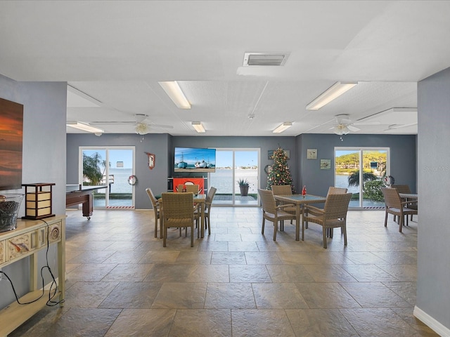 464 N Paula Dr Unit 106, Dunedin, FL 34698 - dining area with stone tile flooring, ceiling fan, and healthy amount of natural light