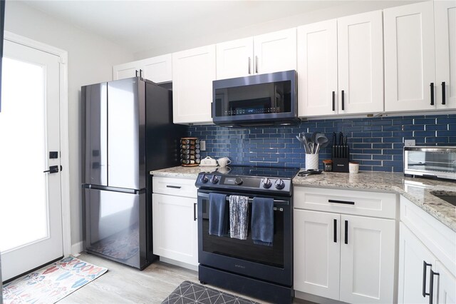 72 Pine Island Cir, Kissimmee, FL 34743 - kitchen with stainless steel appliances, backsplash, and white cabinetry