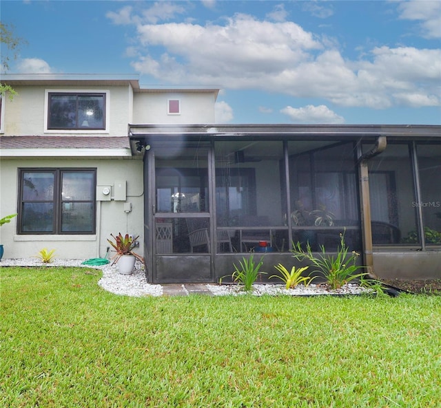 72 Pine Island Cir, Kissimmee, FL 34743 - back of house featuring stucco siding, a sunroom, and a lawn