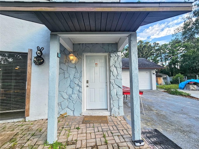 10928 Echo Loop, New Port Richey, FL 34654 - view of exterior entry with stone siding, stucco siding, a garage, and driveway
