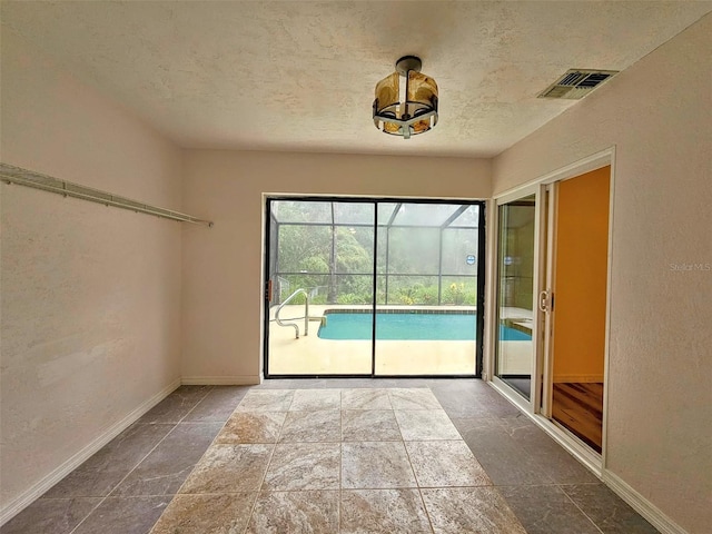 10928 Echo Loop, New Port Richey, FL 34654 - unfurnished room featuring a textured ceiling and stone finish flooring