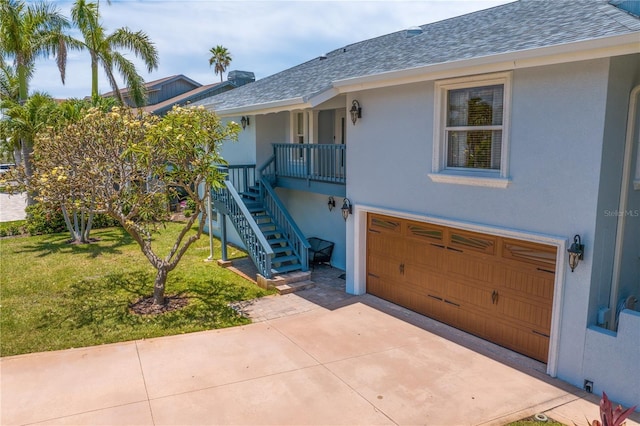 131 N Tessier Dr, St Pete Beach, FL 33706 - view of front facade with an attached garage, a front lawn, stairs, a shingled roof, and driveway