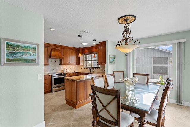 131 N Tessier Dr, St Pete Beach, FL 33706 - dining room with healthy amount of natural light, a textured ceiling, light tile patterned flooring, and recessed lighting