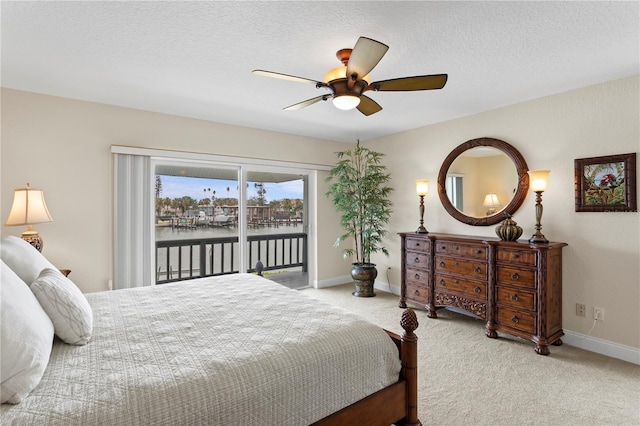 131 N Tessier Dr, St Pete Beach, FL 33706 - bedroom featuring access to outside, carpet flooring, a water view, ceiling fan, and a textured ceiling
