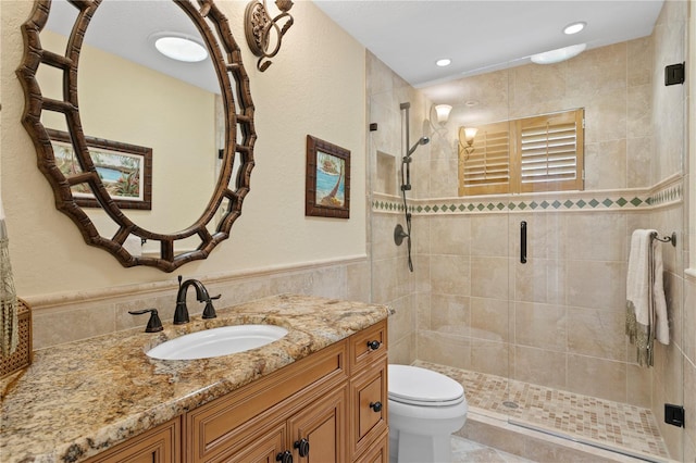 131 N Tessier Dr, St Pete Beach, FL 33706 - bathroom with a stall shower, tile walls, vanity, a wainscoted wall, and recessed lighting