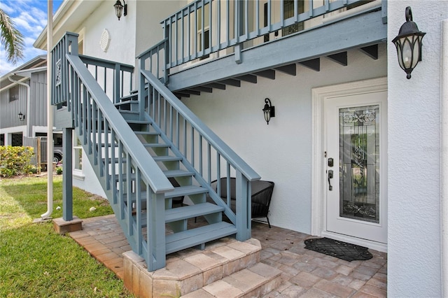 131 N Tessier Dr, St Pete Beach, FL 33706 - view of exterior entry with stucco siding and a lawn