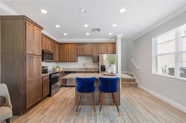527 Jetstar Ln, Oldsmar, FL 34677 - kitchen featuring stainless steel appliances, crown molding, a kitchen breakfast bar, recessed lighting, and a center island