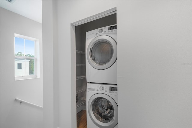 527 Jetstar Ln, Oldsmar, FL 34677 - laundry room featuring stacked washer and clothes dryer and wood finished floors