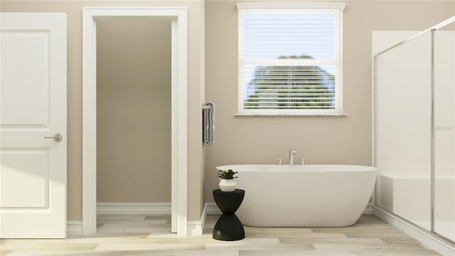 6913 116th Ct E, Palmetto, FL 34221 - bathroom with a freestanding tub, healthy amount of natural light, wood finished floors, and a tile shower