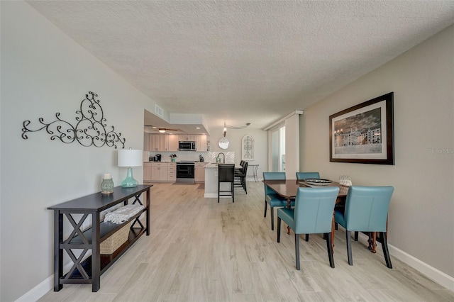17408 Gulf Blvd Unit 601, Redington Shores, FL 33708 - dining area featuring light wood-type flooring and a textured ceiling