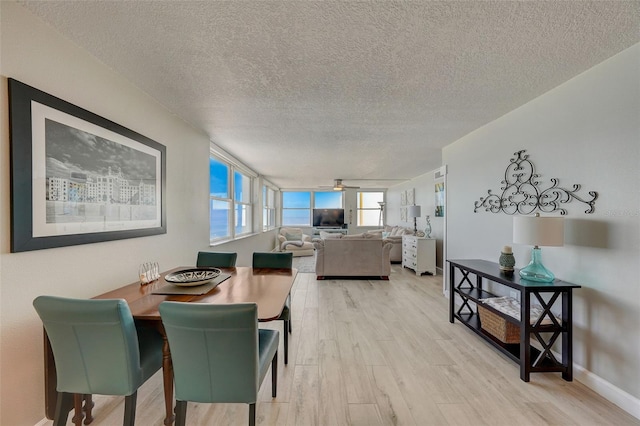 17408 Gulf Blvd Unit 601, Redington Shores, FL 33708 - dining area featuring light wood-style flooring, a textured ceiling, and a ceiling fan