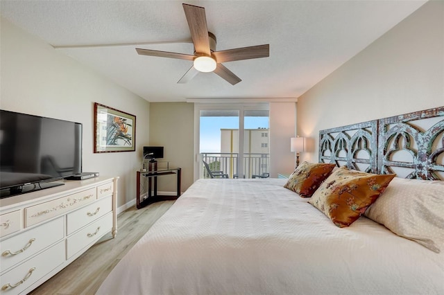 17408 Gulf Blvd Unit 601, Redington Shores, FL 33708 - bedroom with access to exterior, light wood finished floors, ceiling fan, and a textured ceiling