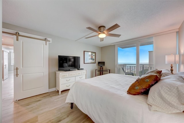 17408 Gulf Blvd Unit 601, Redington Shores, FL 33708 - bedroom featuring light wood finished floors, access to outside, a barn door, and a ceiling fan