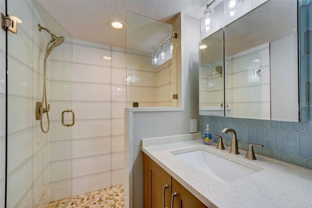 17408 Gulf Blvd Unit 601, Redington Shores, FL 33708 - bathroom with a shower stall, vanity, a textured ceiling, and tasteful backsplash