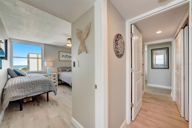 17408 Gulf Blvd Unit 601, Redington Shores, FL 33708 - bedroom with light wood-style flooring, a textured ceiling, and ceiling fan