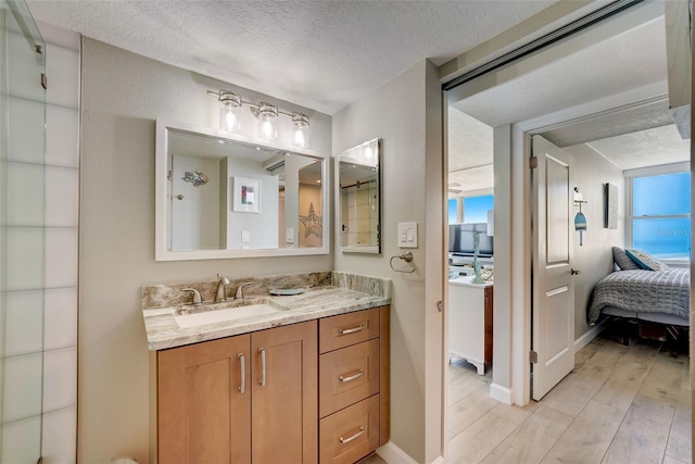 17408 Gulf Blvd Unit 601, Redington Shores, FL 33708 - bathroom featuring vanity, a textured ceiling, ensuite bathroom, and wood finished floors