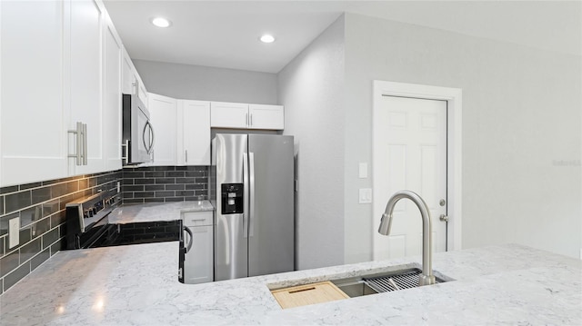 3051 27th Ct E, Palmetto, FL 34221 - kitchen with appliances with stainless steel finishes, light stone countertops, tasteful backsplash, white cabinets, and recessed lighting