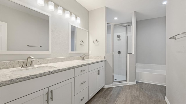 3051 27th Ct E, Palmetto, FL 34221 - bathroom featuring a stall shower, double vanity, wood finished floors, a garden tub, and recessed lighting