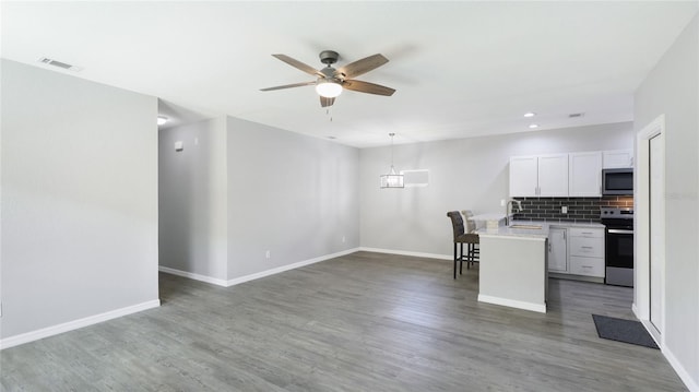 3051 27th Ct E, Palmetto, FL 34221 - kitchen with appliances with stainless steel finishes, ceiling fan, white cabinetry, light countertops, and decorative backsplash